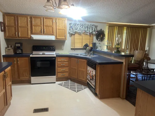 a kitchen with stainless steel appliances granite countertop a stove a sink and a microwave