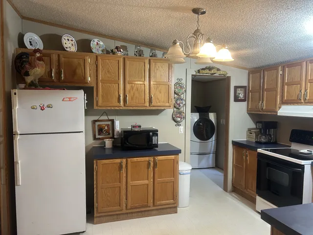 a kitchen with stainless steel appliances granite countertop a refrigerator a sink a stove and a cabinets