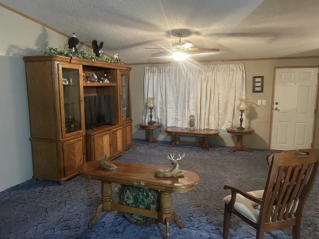 a living room with furniture a chandelier and a dining table