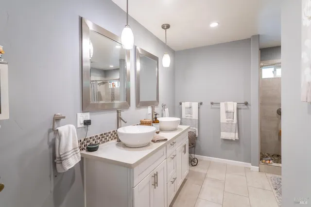 a bathroom with a double vanity sink a mirror and a shower