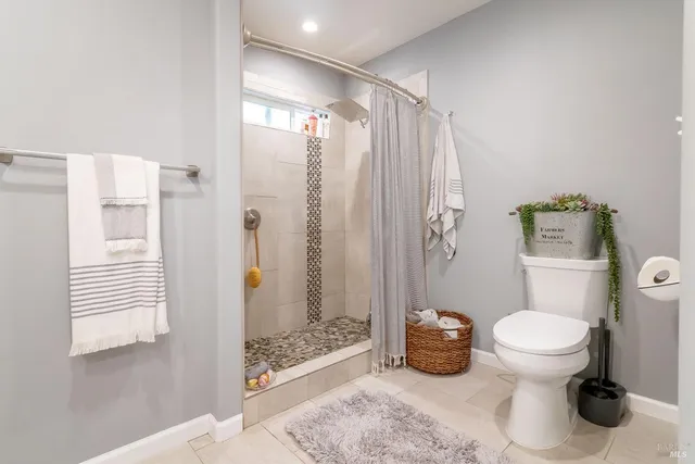 a bathroom with a toilet and a shower