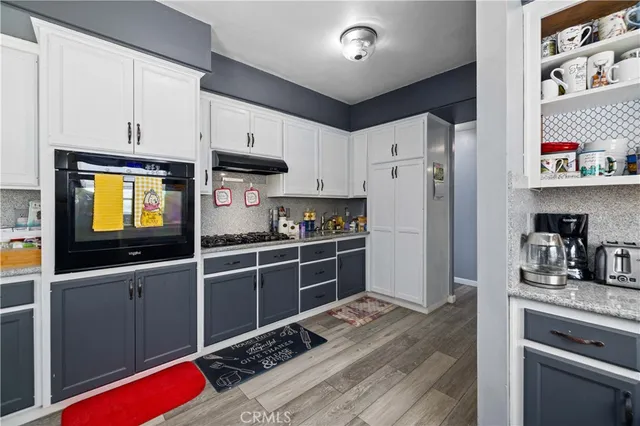 a kitchen with stainless steel appliances kitchen island granite countertop a sink stove and refrigerator