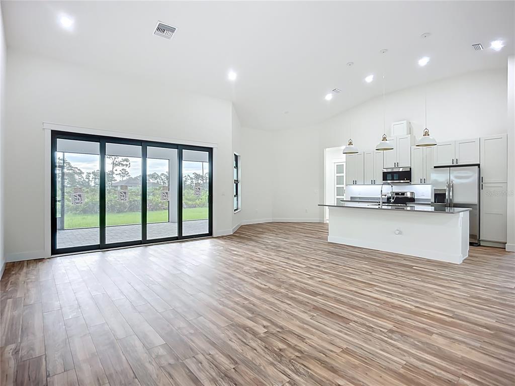 15 Heave Lane Placida, FL 33946 - Photo 12 of 70 a view of kitchen with granite countertop a stove top oven a sink and white cabinets with wooden floor