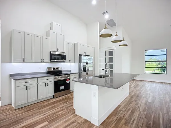 a kitchen with stainless steel appliances granite countertop a stove and a wooden floors