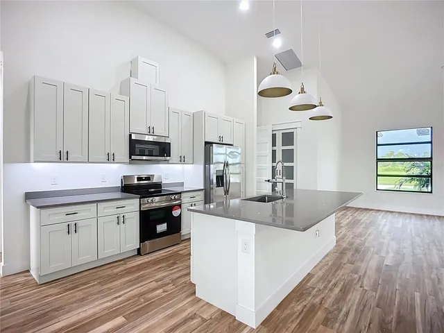 a kitchen with stainless steel appliances granite countertop a stove and a wooden floors