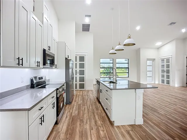 a kitchen with stainless steel appliances granite countertop a sink and a refrigerator