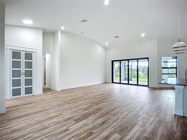 a view of a hallway with wooden floor and entryway