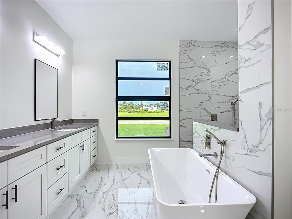 15 Heave Lane Placida, FL 33946 - Photo 39 of 70 a bathroom with a granite countertop sink a bathtub and next to a window