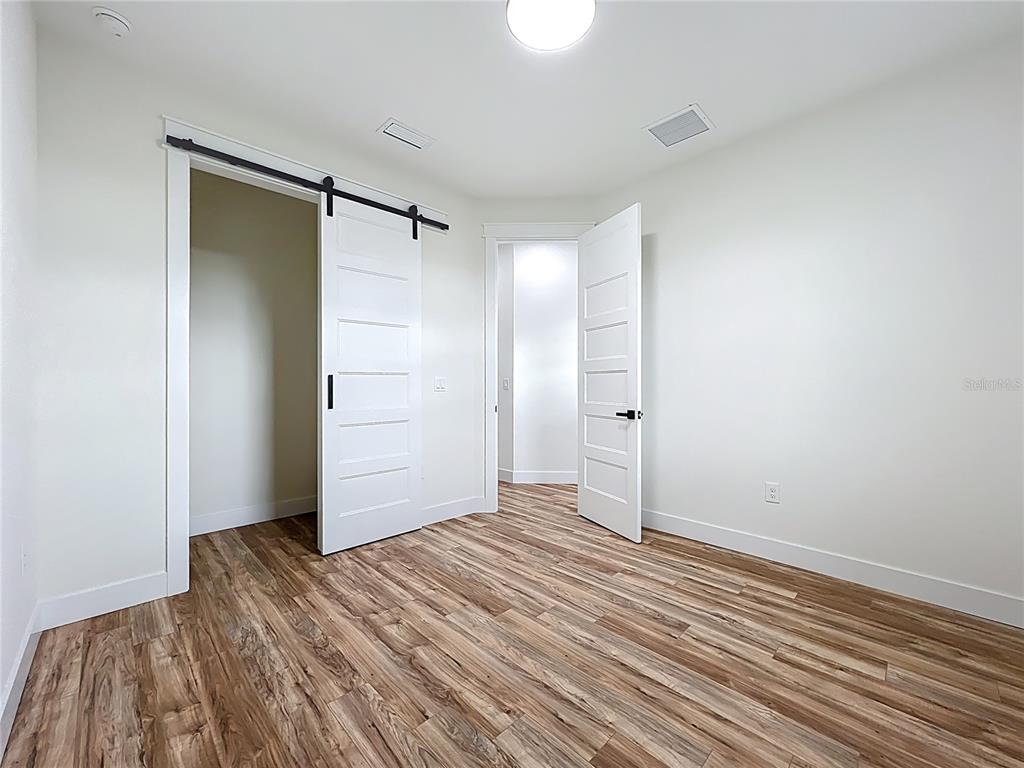 15 Heave Lane Placida, FL 33946 - Photo 48 of 70 an empty room with wooden floor and a bathroom