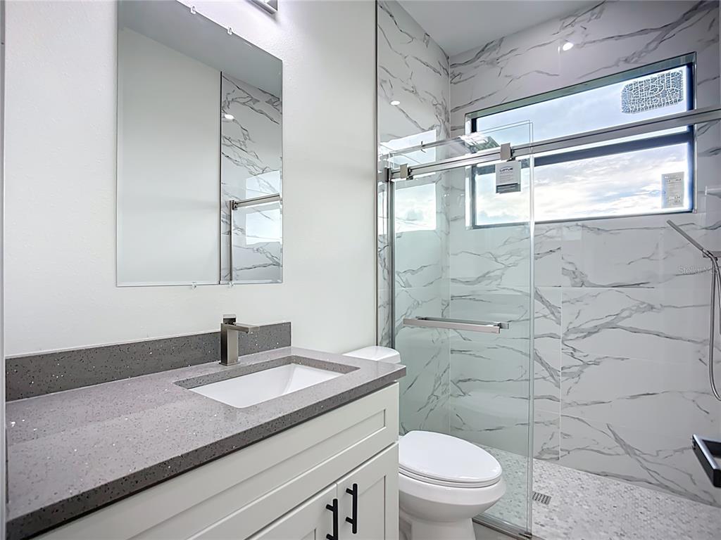 15 Heave Lane Placida, FL 33946 - Photo 49 of 70 a bathroom with a granite countertop sink toilet a mirror and shower