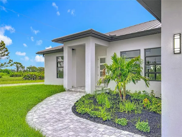 a view of a house with potted plants and a yard
