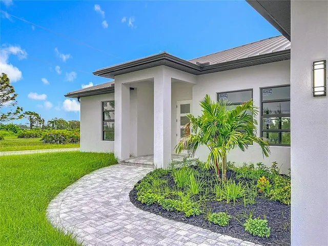 a view of a house with potted plants and a yard