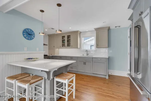 a kitchen with a sink a counter top space stainless steel appliances and cabinets