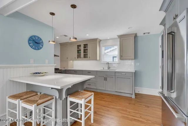 a kitchen with a sink a counter top space stainless steel appliances and cabinets