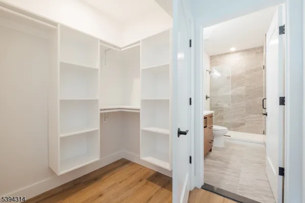 a bathroom with a walk in closet and wooden floor