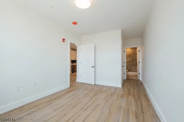 a view of an empty room with closet and a window