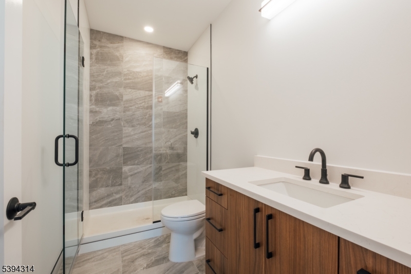 67 Summer Avenue, Unit 101 Newark, NJ 07104 - Photo 9 of 26 a bathroom with a sink mirror toilet and shower