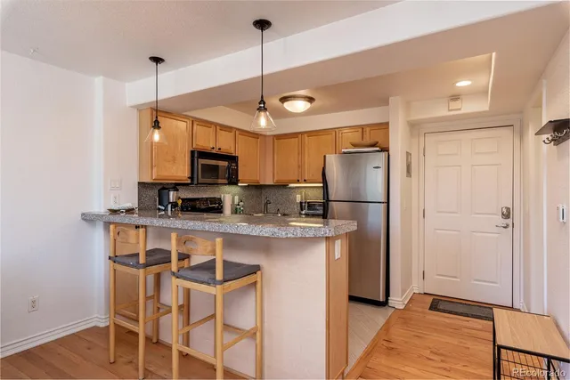 a kitchen with stainless steel appliances granite countertop a refrigerator a stove a sink and a microwave