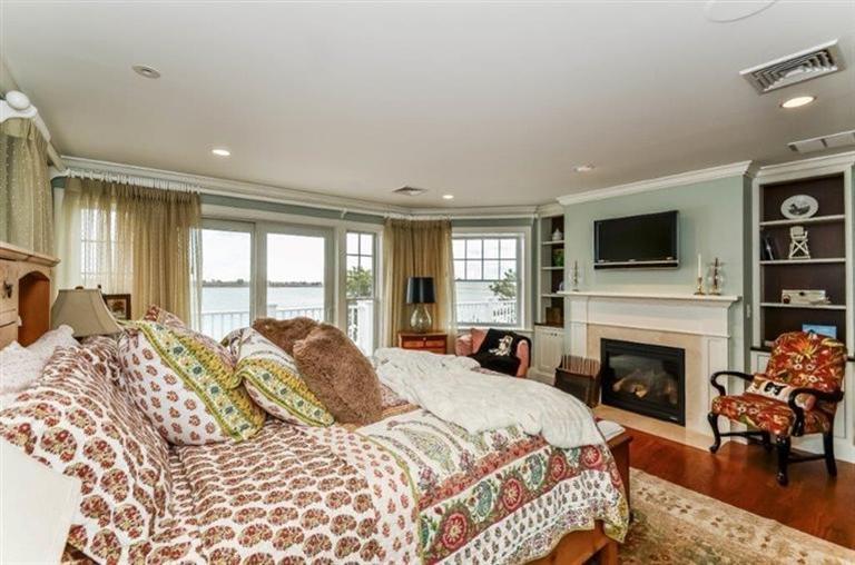 6 Yacht Club Road Falmouth, MA 02536 - Photo 22 of 35 a large bedroom with a bed and a fireplace