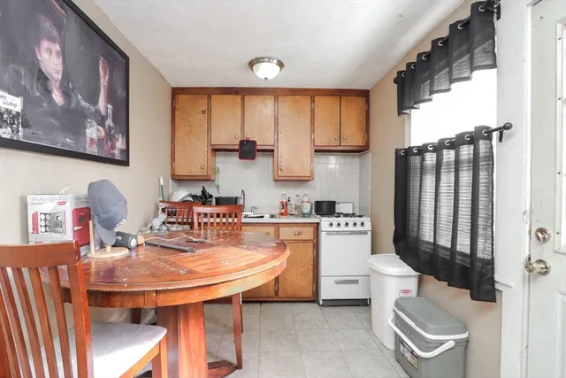 a large kitchen with a table chairs and a refrigerator