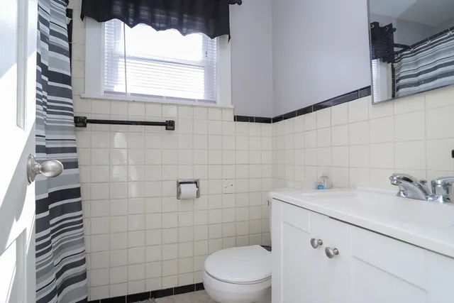 a bathroom with a sink toilet and window