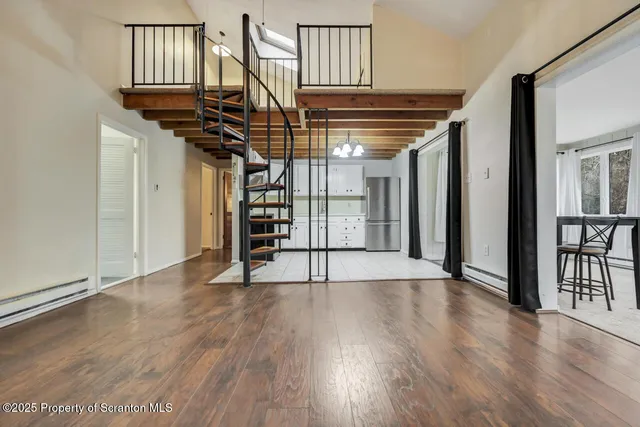 a view of a hallway with wooden floor and entryway