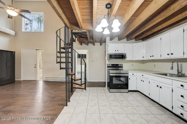 a kitchen with granite countertop a refrigerator sink and cabinets