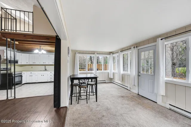 a view of empty room with wooden floor and windows