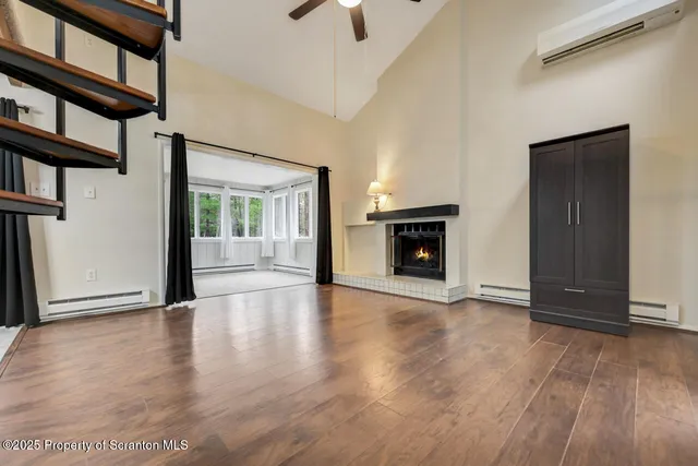 wooden floor fireplace and windows in an empty room