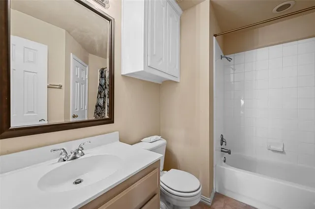 a bathroom with a bathtub shower sink vanity and toilet