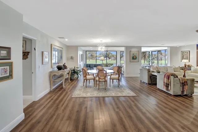 a view of a dining room with furniture large windows and wooden floor