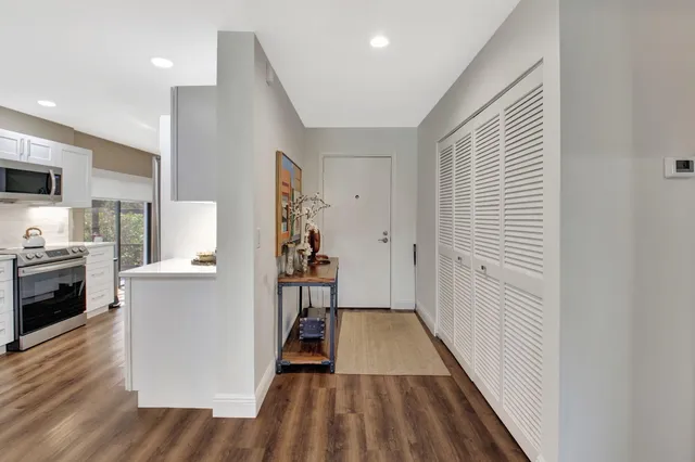 a kitchen with granite countertop lots of counter top space a sink a refrigerator and cabinets