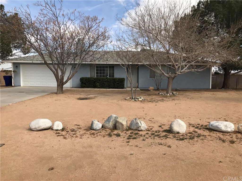 13141 Setancket Road Apple Valley, CA 92308 - Photo 1 of 1 a view of a white house with a yard
