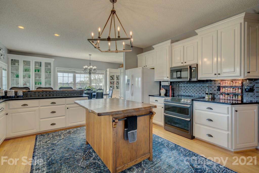 1481 Airport Road Rutherfordton, NC 28139 - Photo 28 of 47 a kitchen with stainless steel appliances kitchen island granite countertop a sink a stove and cabinets