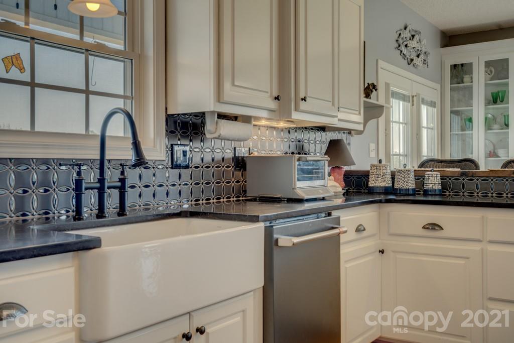 1481 Airport Road Rutherfordton, NC 28139 - Photo 32 of 47 a kitchen with stainless steel appliances granite countertop a sink and a white cabinets