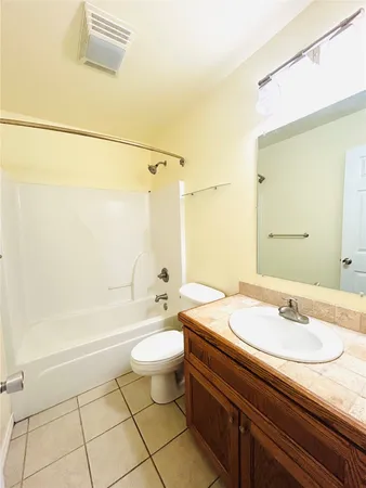 a bathroom with a granite countertop sink a toilet a mirror and bathtub