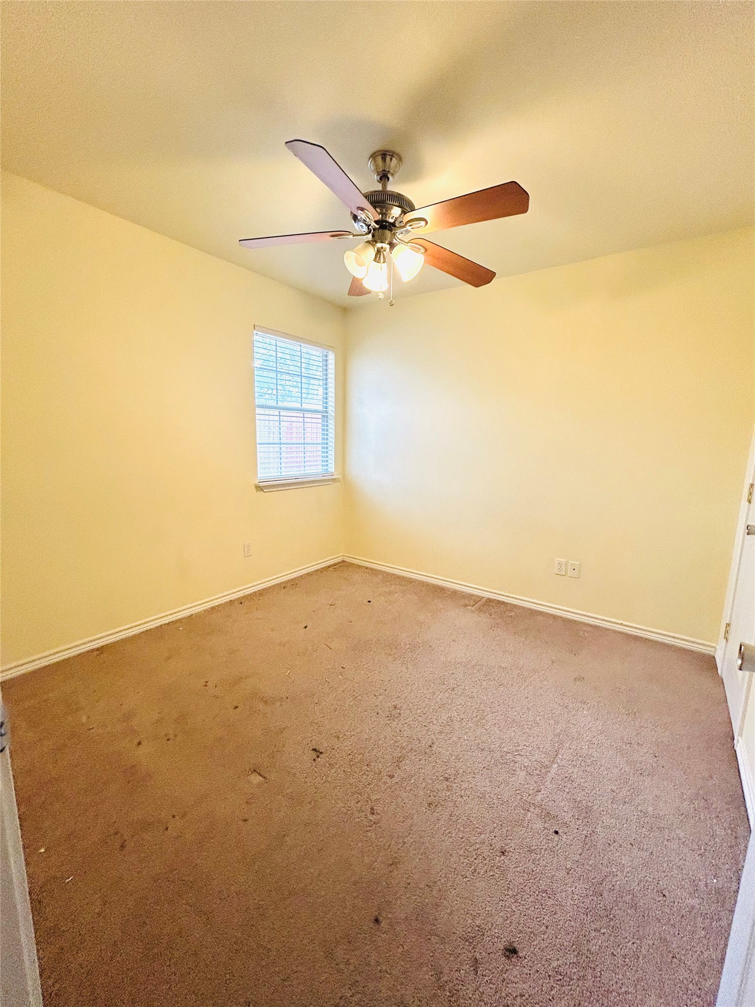 206 Milentz Street Columbus, TX 78934 - Photo 8 of 10 an empty room with a window and a ceiling fan