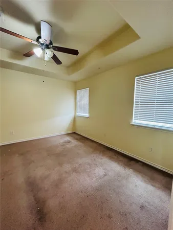 an empty room with a ceiling fan and window