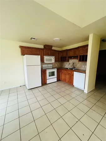 a kitchen with a stove top oven and cabinets