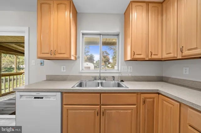 a kitchen with stainless steel appliances granite countertop white cabinets and a sink