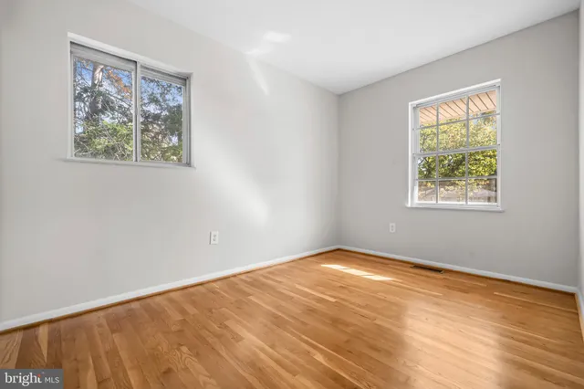 a view of an empty room with a window and a bookshelf