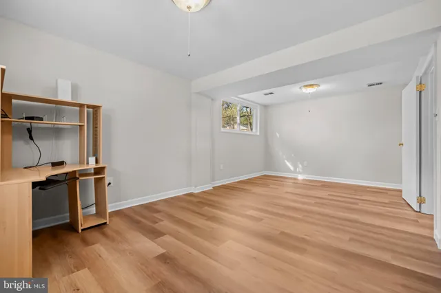 a view of empty room with wooden floor