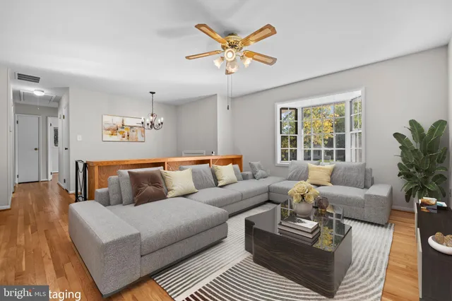 a living room with furniture ceiling fan and a window