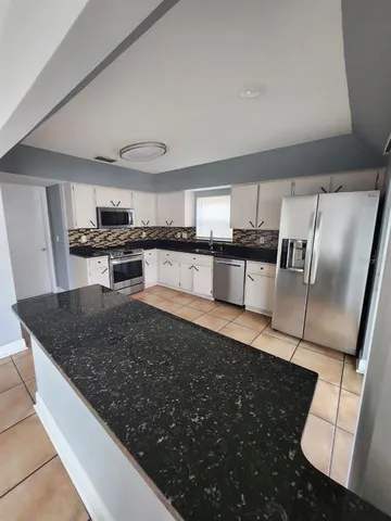 a kitchen with stainless steel appliances cabinets a sink and a stove