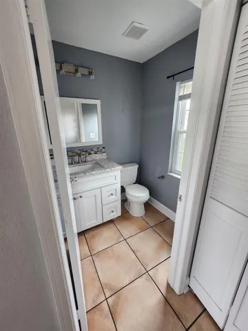 a bathroom with a sink toilet vanity and mirror
