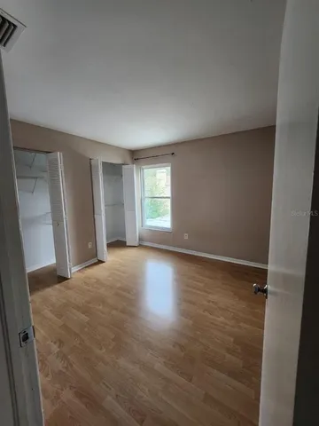 an empty room with closet and windows