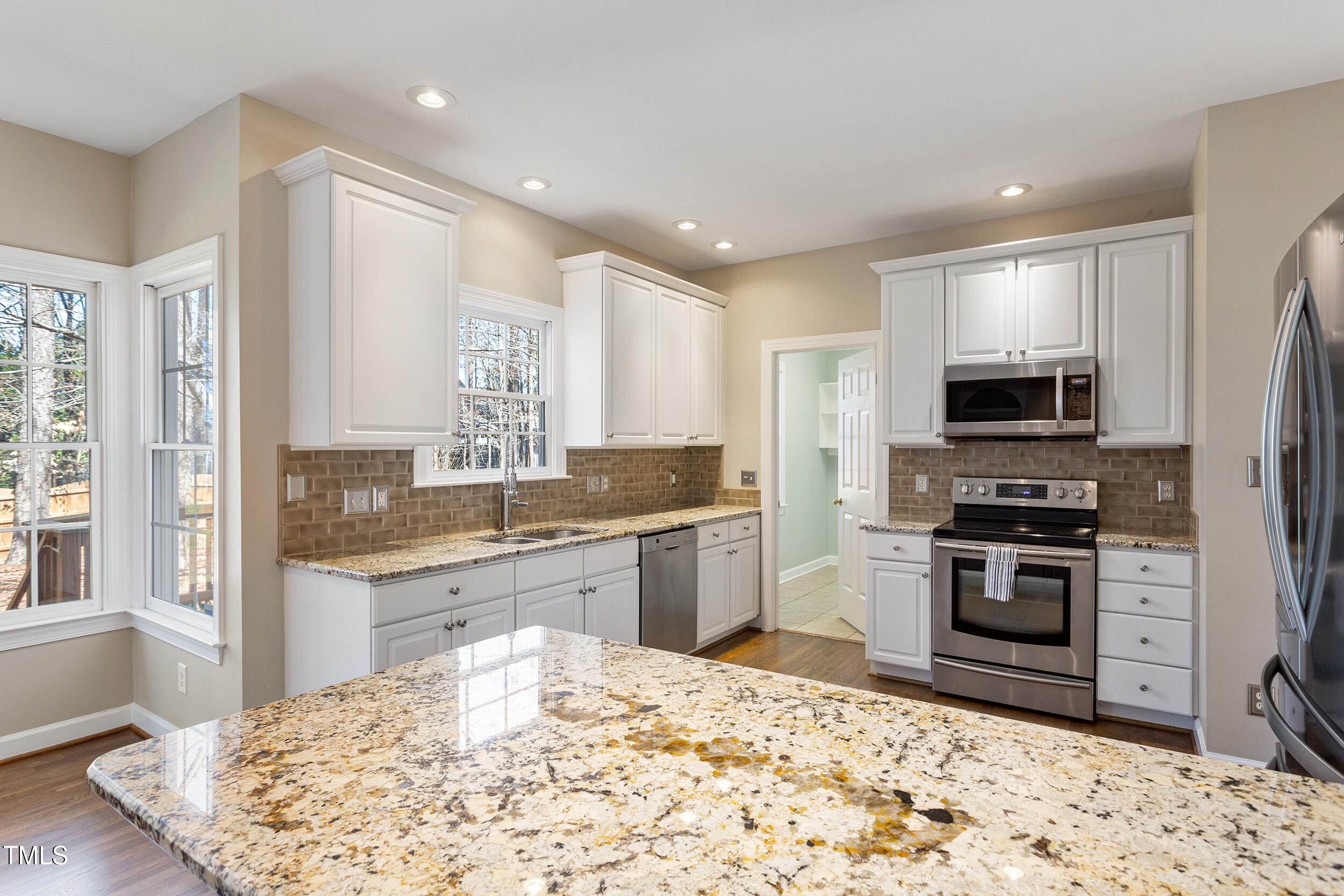 501 Nantucket Drive Cary, NC 27513 - Photo 11 of 34 a kitchen with stainless steel appliances granite countertop a stove top oven a sink and a refrigerator