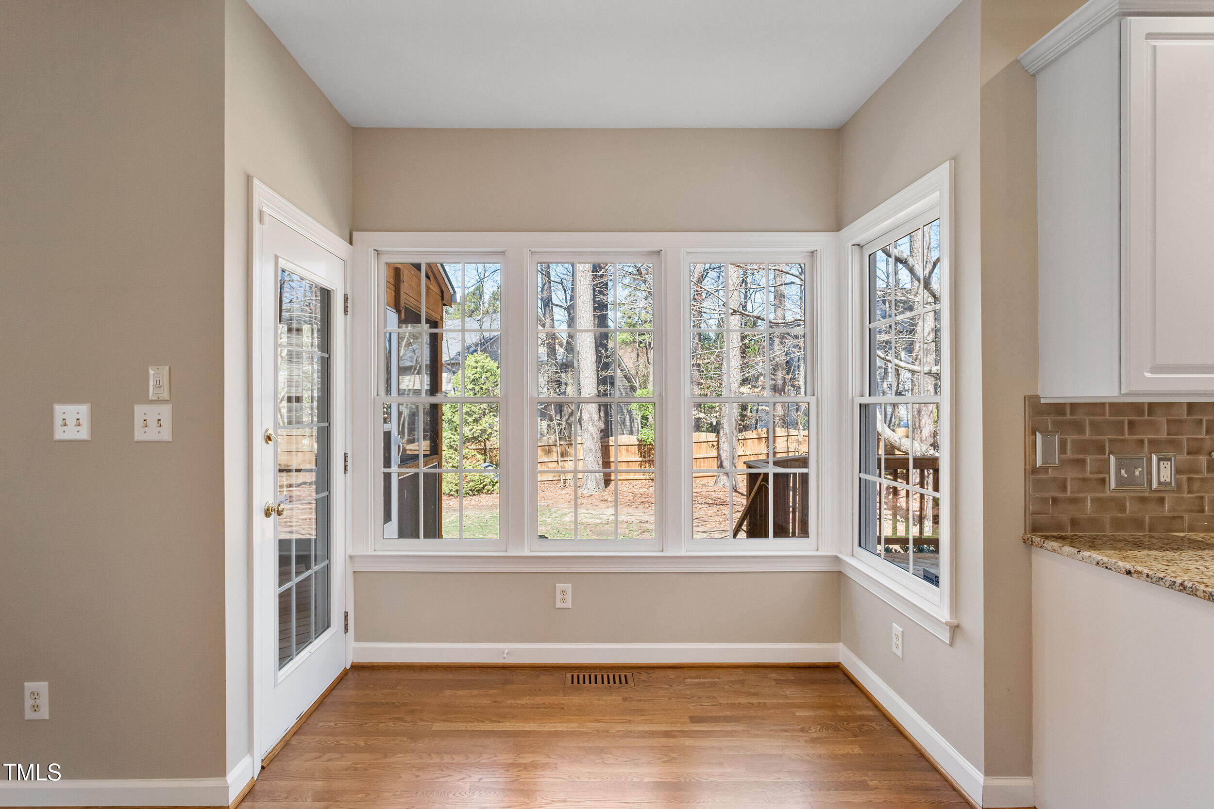 501 Nantucket Drive Cary, NC 27513 - Photo 16 of 34 a view of an empty room with wooden floor and windows