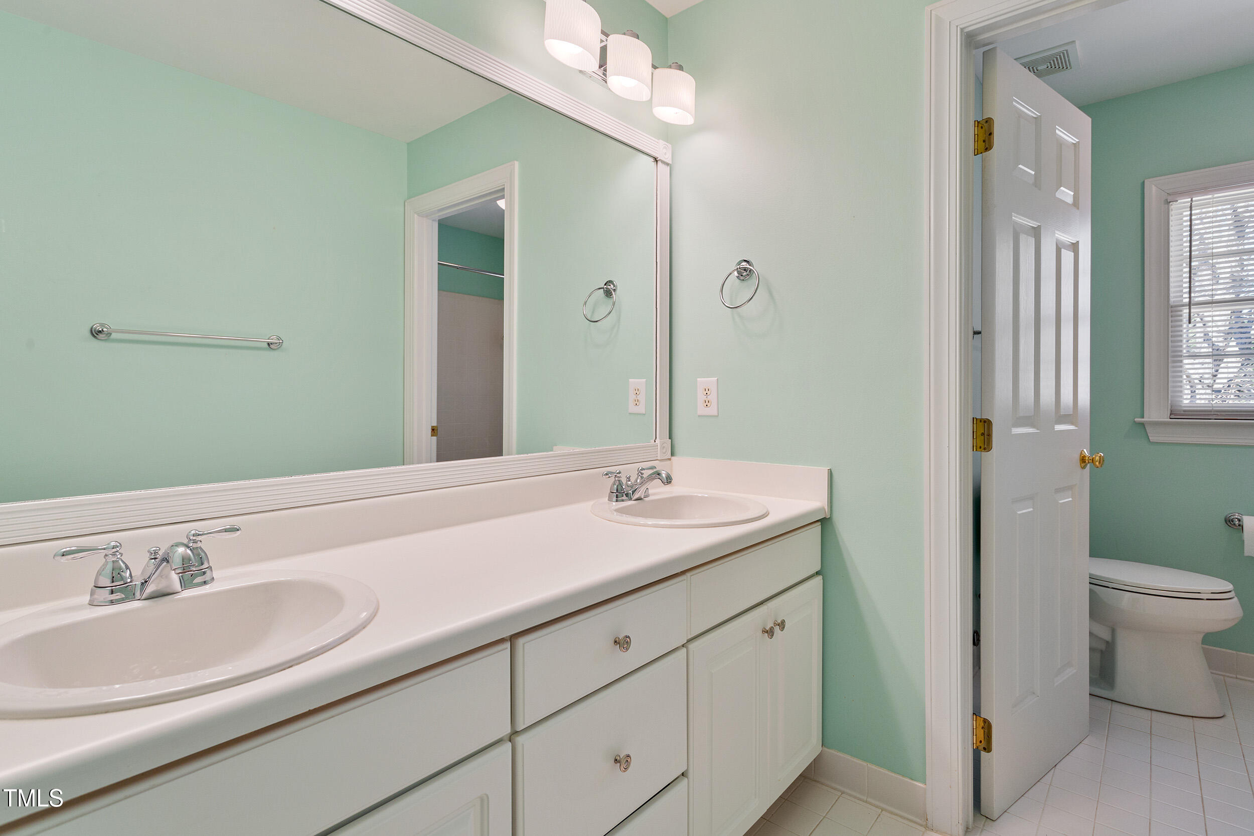 501 Nantucket Drive Cary, NC 27513 - Photo 26 of 34 a bathroom with a granite countertop sink and a large mirror