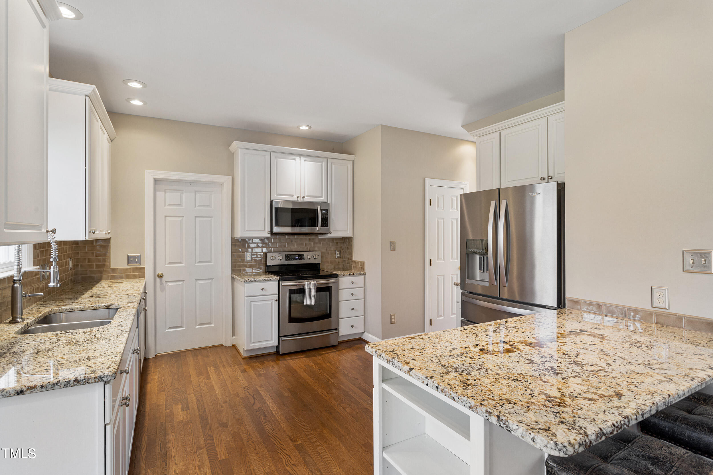 501 Nantucket Drive Cary, NC 27513 - Photo 10 of 34 a kitchen with stainless steel appliances granite countertop a sink stove microwave and refrigerator